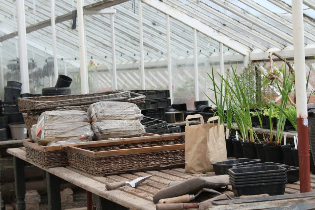 a wooden table topped with lots of pots and plants