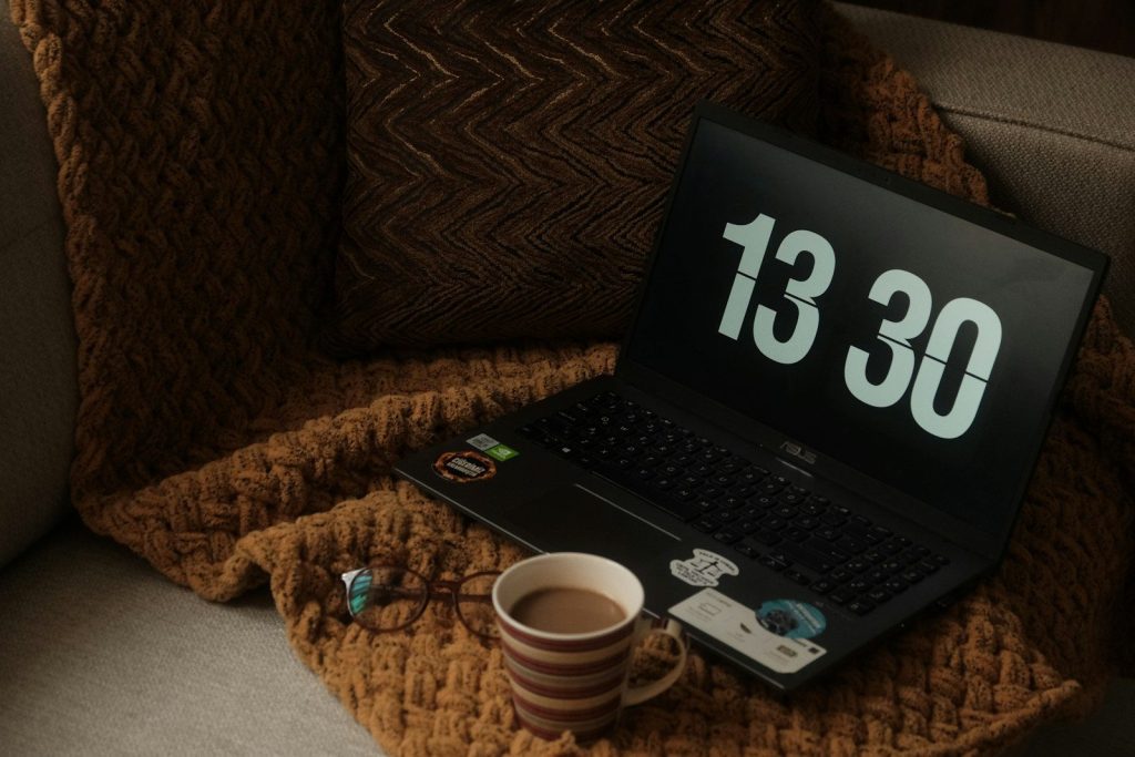 a laptop computer sitting on top of a couch next to a cup of coffee