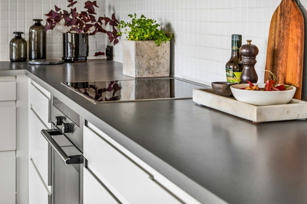 A kitchen with stainless steel counter tops and white cabinets