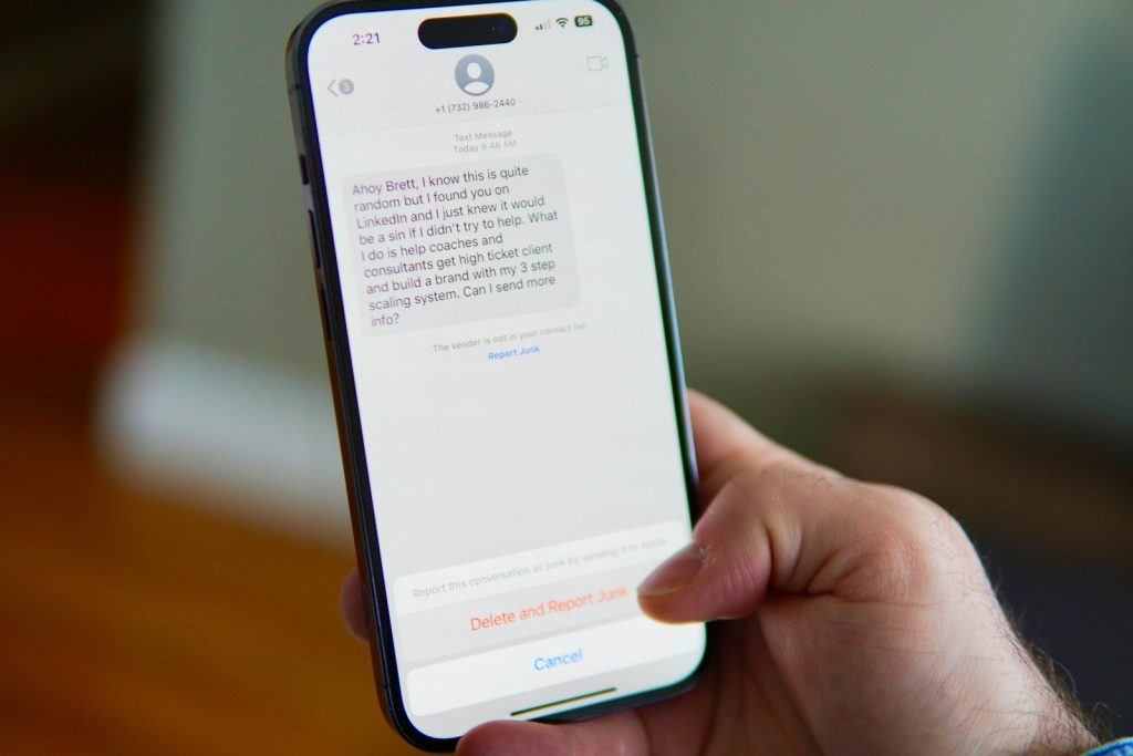 Hand holding a smartphone displaying a text message conversation.