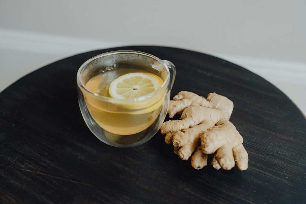 a glass of ginger tea with a slice of lemon