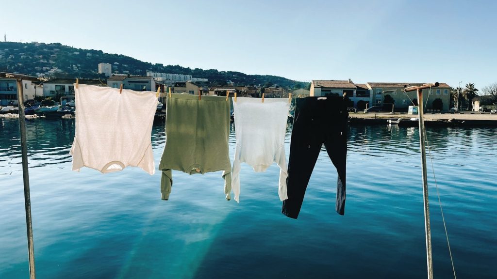 A row of clothes hanging on a clothes line over a body of water