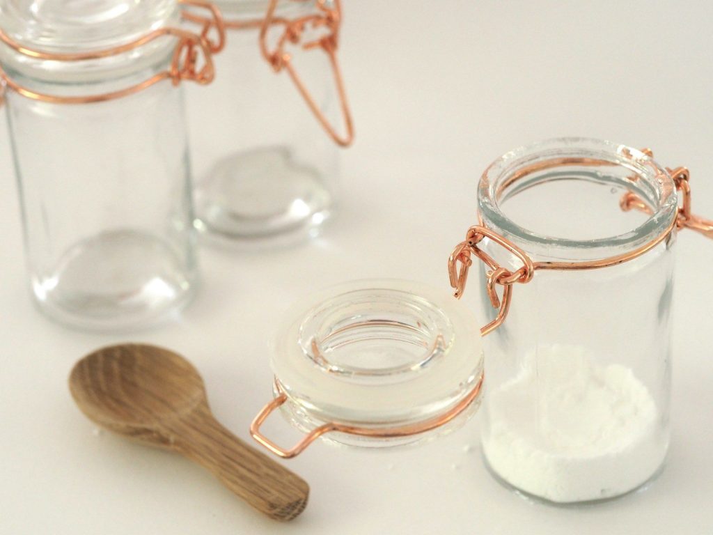 open glass jar near brown wooden spatula