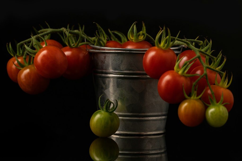 a metal bucket with tomatoes in it