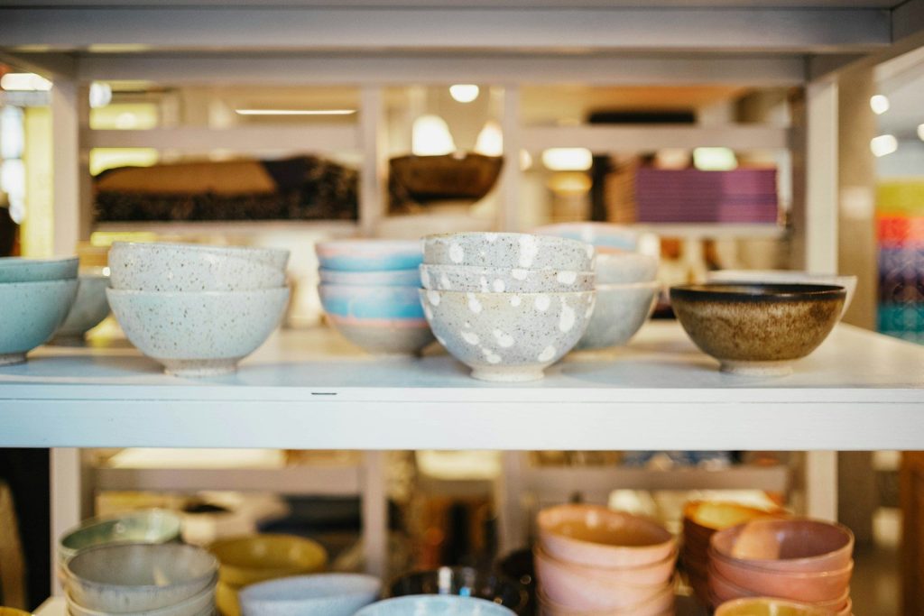 A shelf filled with lots of bowls and bowls