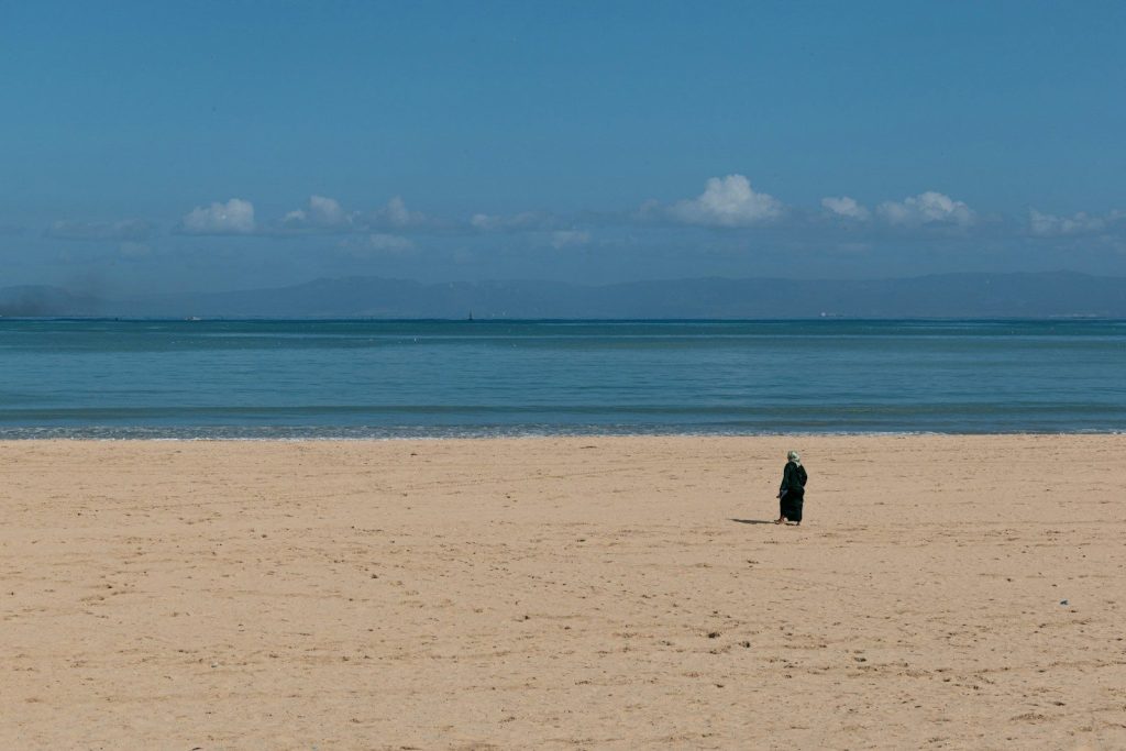 a person standing on a beach near the ocean