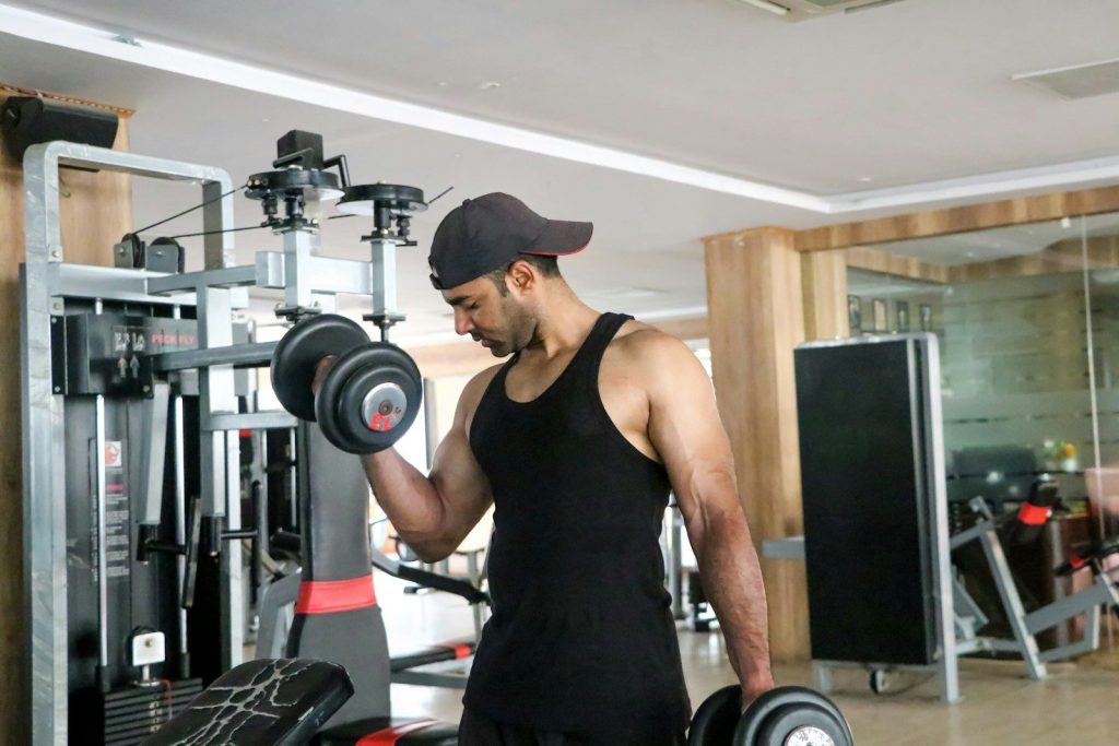 a man in a gym holding a dumbbell