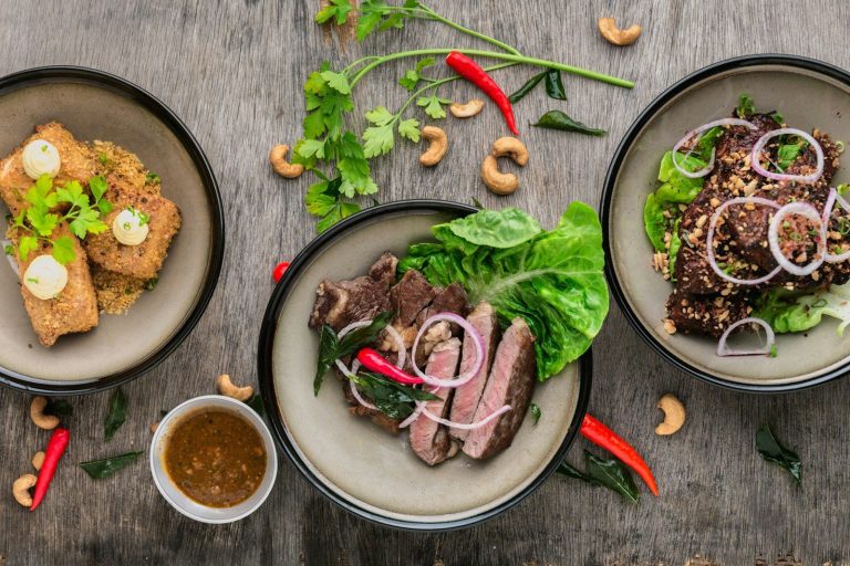 three plates of asian food on wood table