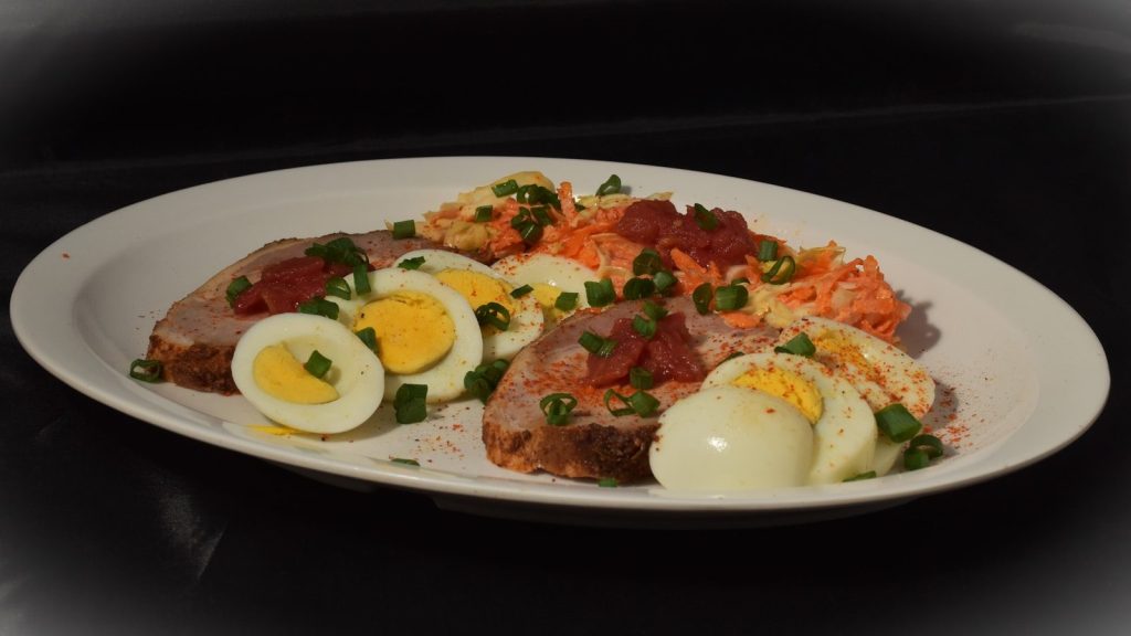 Sliced meat with hard-boiled eggs and salad