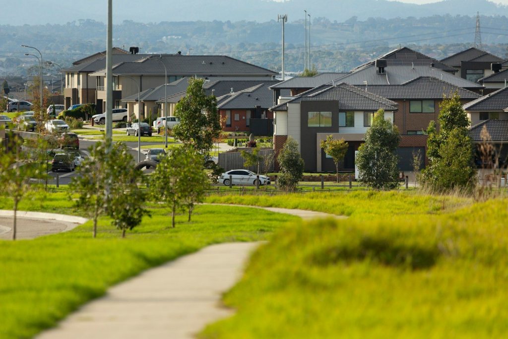 Suburban homes sit in a green, grassy landscape.