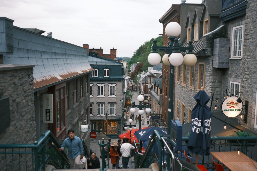 Historic city street with people descending stairs.