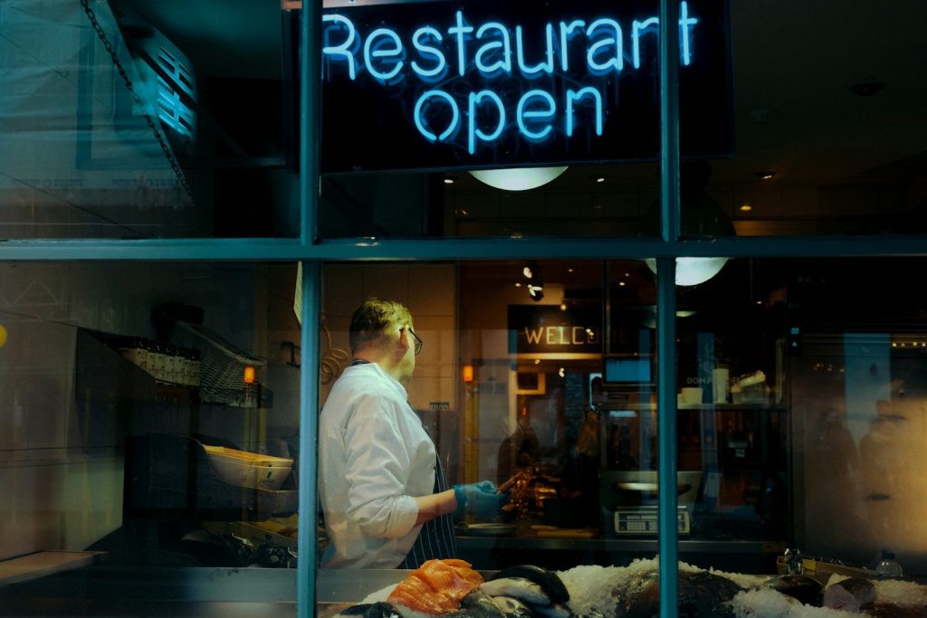a woman standing in front of a restaurant window