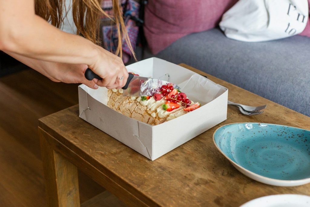 person holding brown box with food