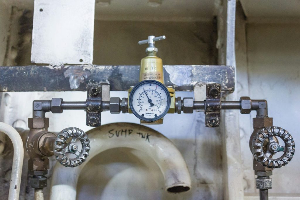 a close up of a toilet with a pressure gauge