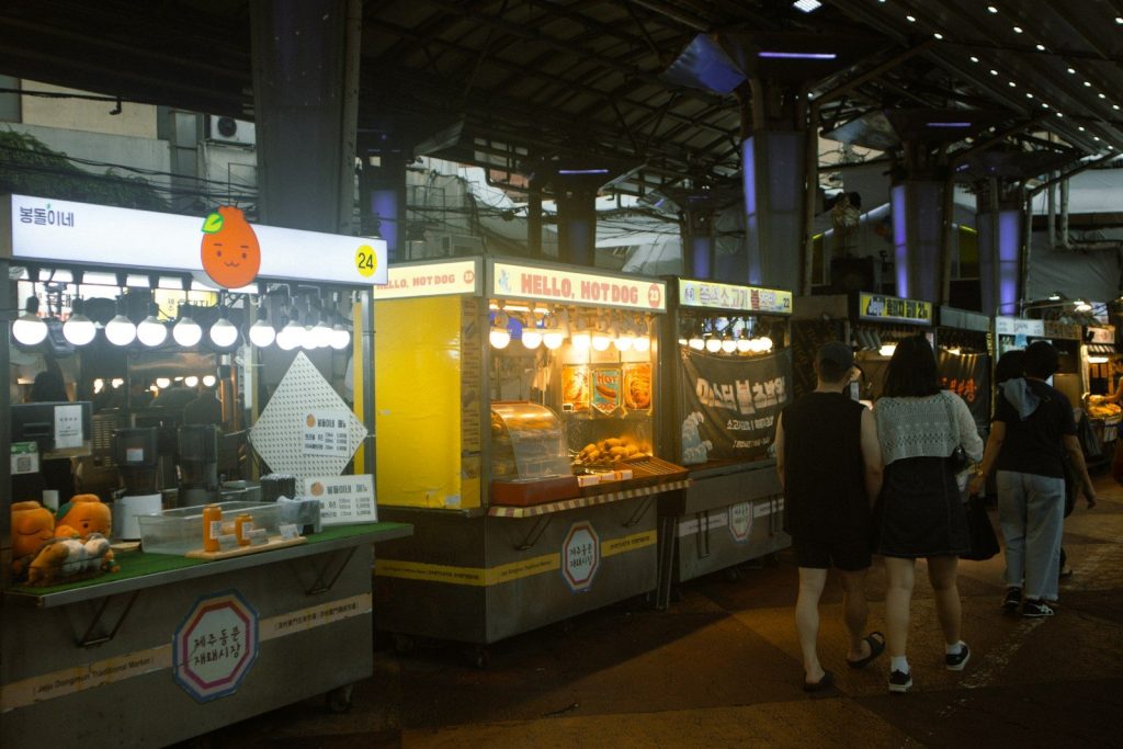 People walking through a night market with food stalls