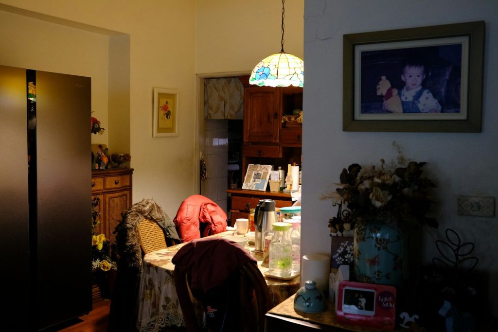 a living room with a table and a refrigerator