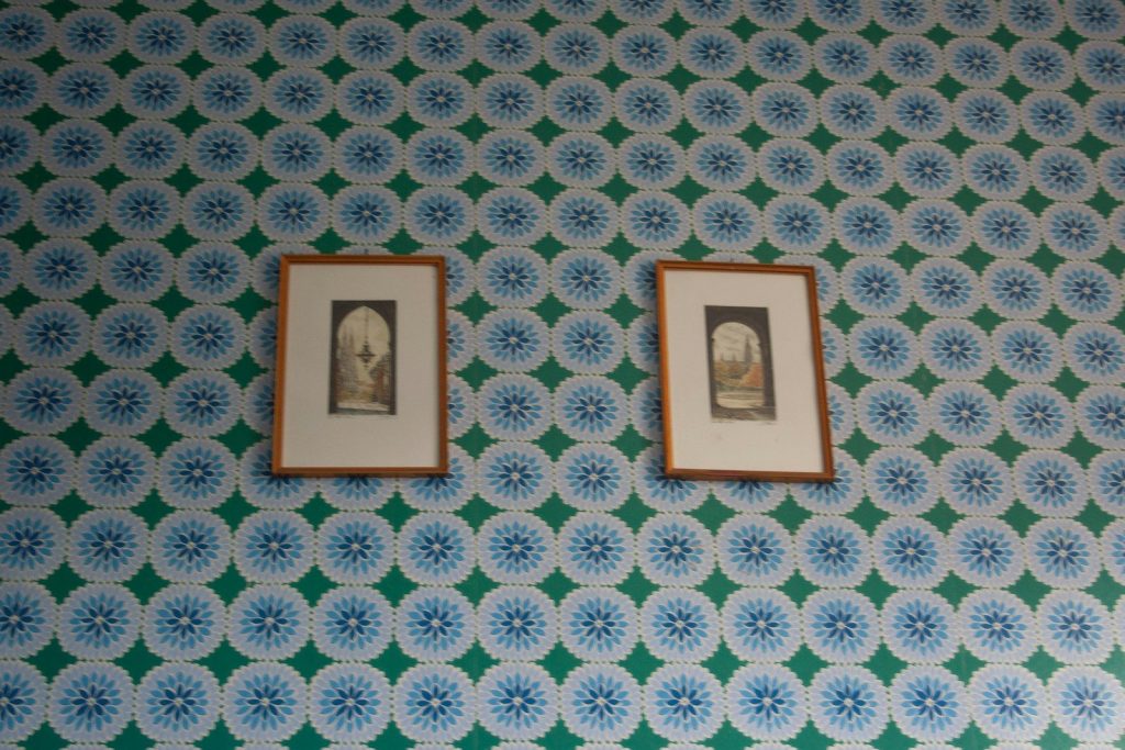A wall with two framed pictures on it
