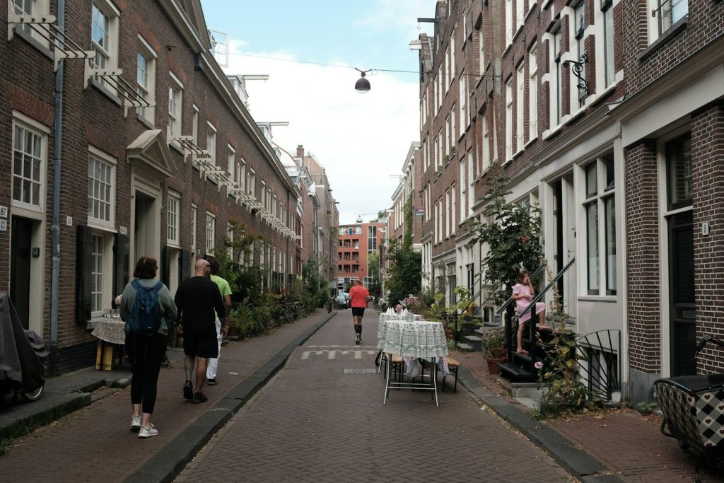 People walking down a narrow street lined with buildings.