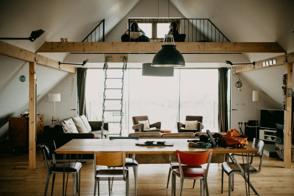 People working in a spacious loft with a large table.