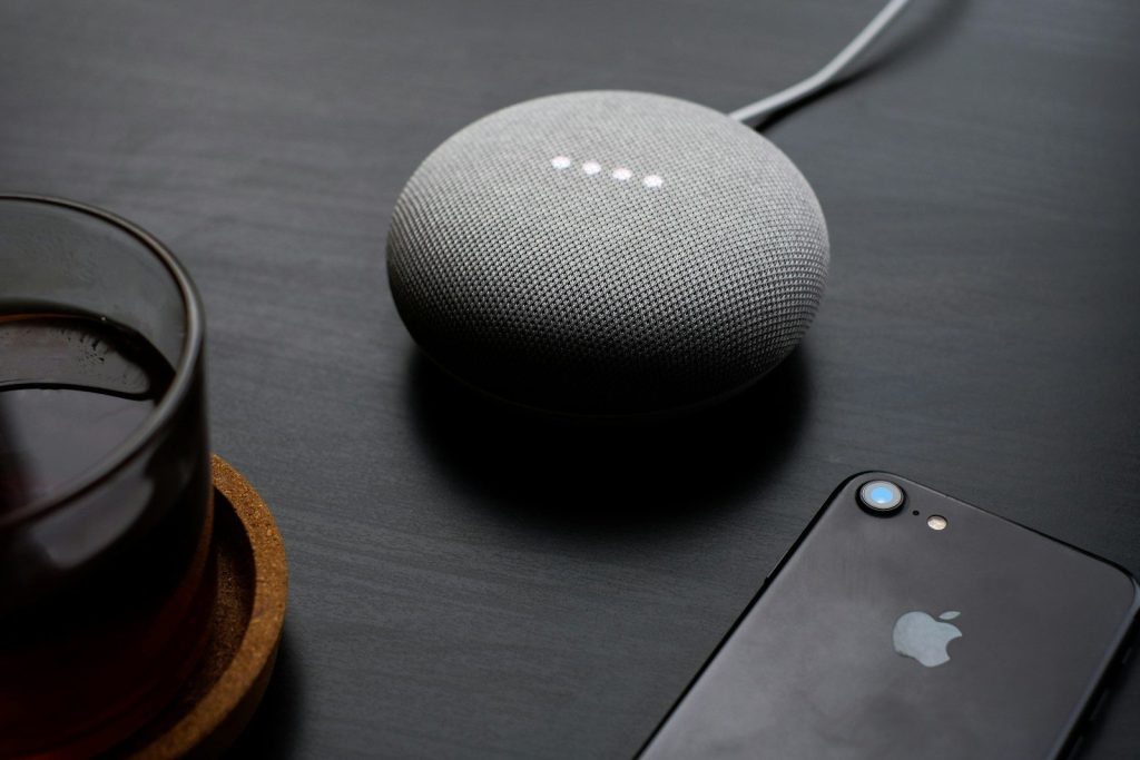 turned-on round gray Google Bluetooth speaker