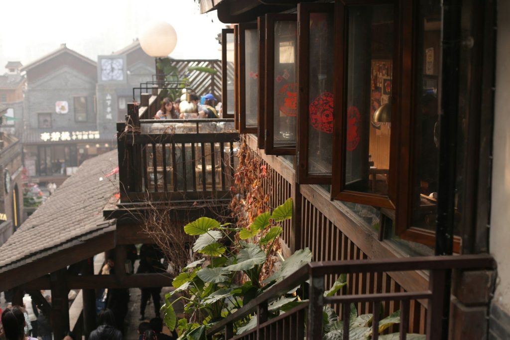 Balcony overlooking old buildings with open windows.