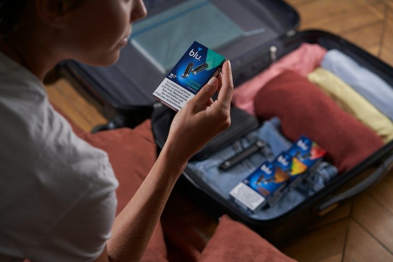 A woman sitting on the floor with a piece of luggage