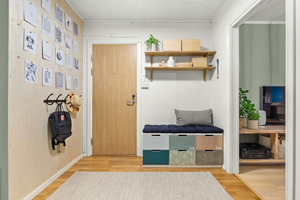 A hallway with a white rug and a wooden door