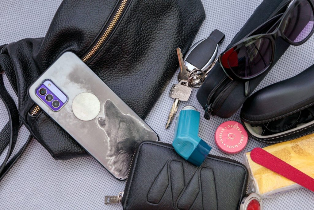 Items from a purse are scattered on a surface.