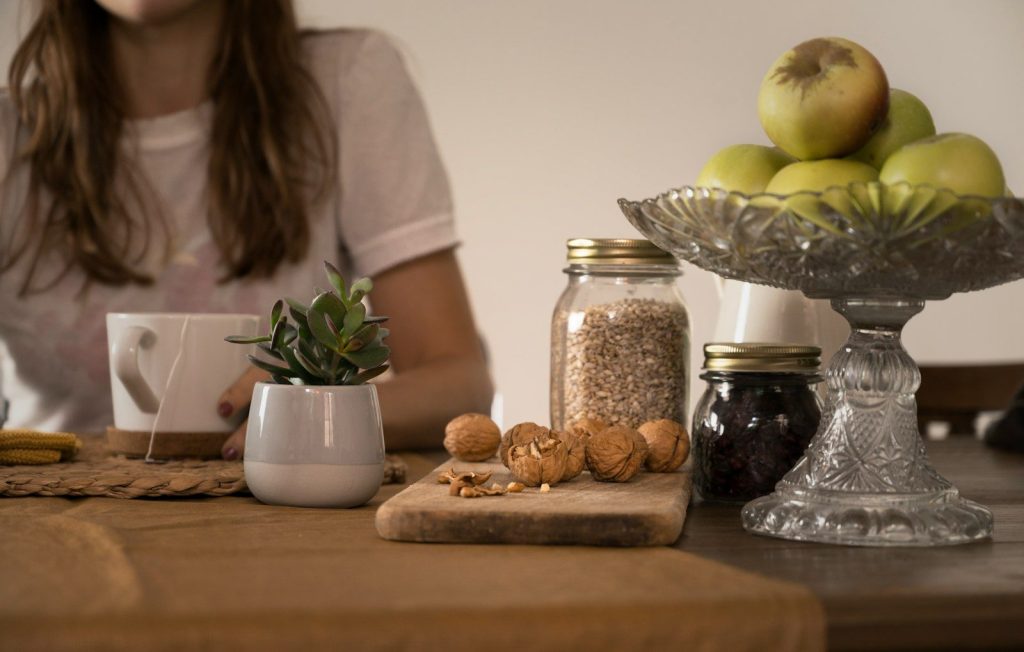 green apple fruit beside clear glass jar on brown wooden table