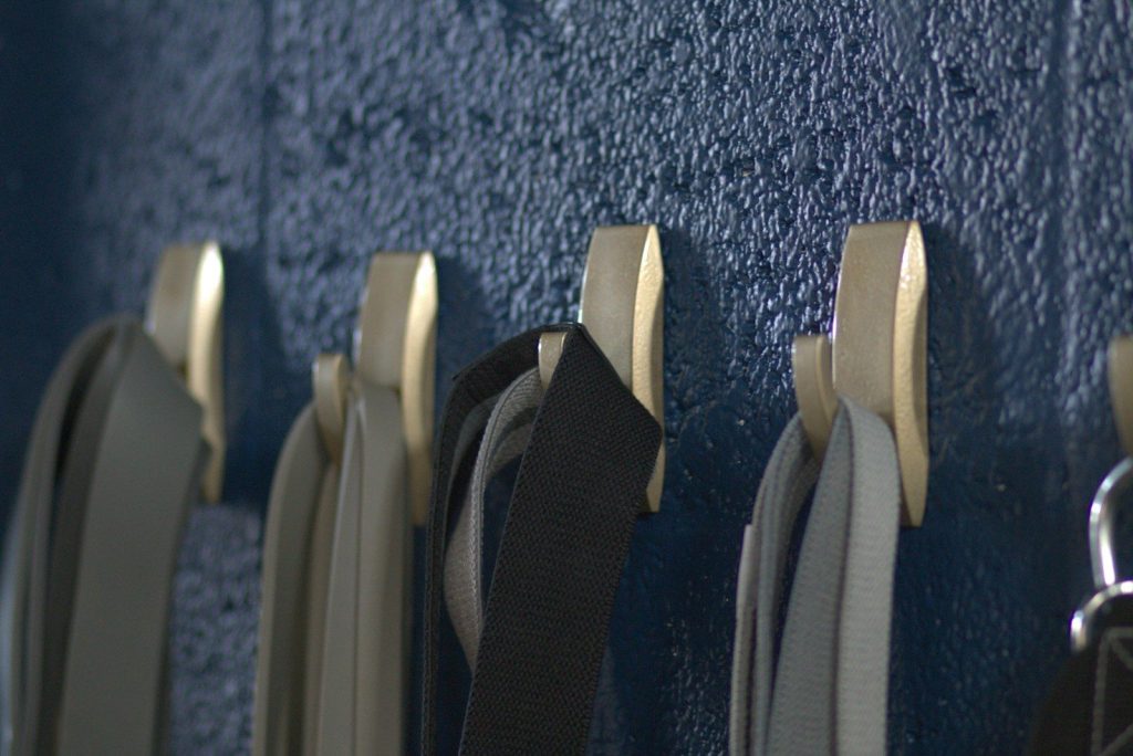a row of metal hooks on a blue wall