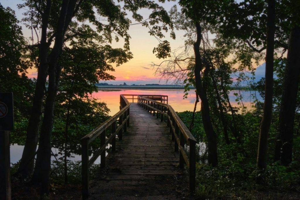 Wooden pier extending into a calm lake at sunset