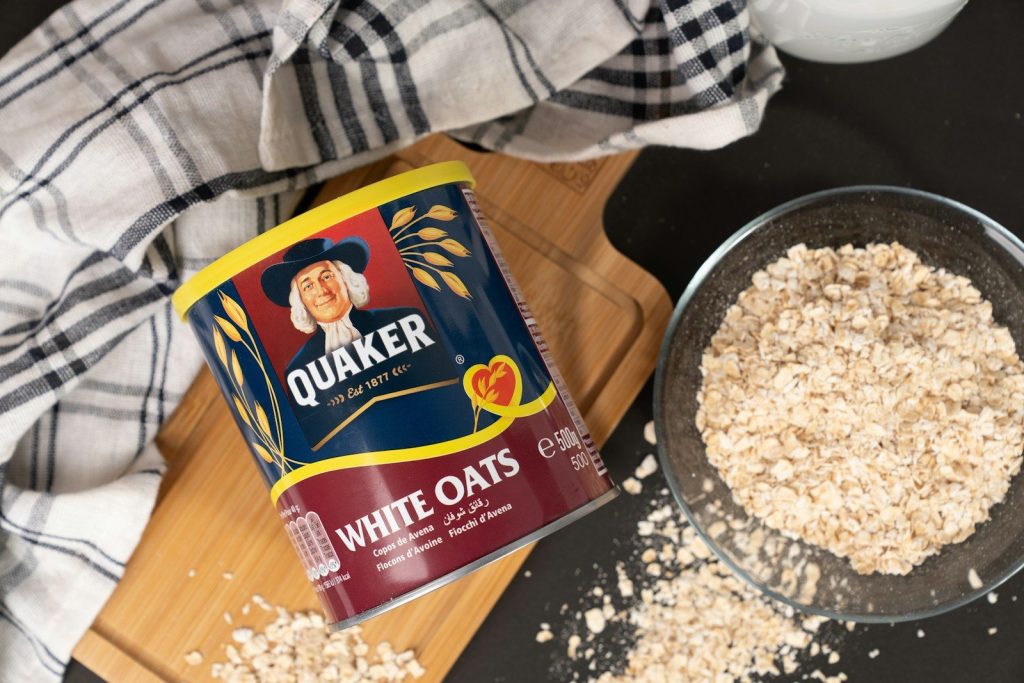 A bowl of oats next to a can of milk