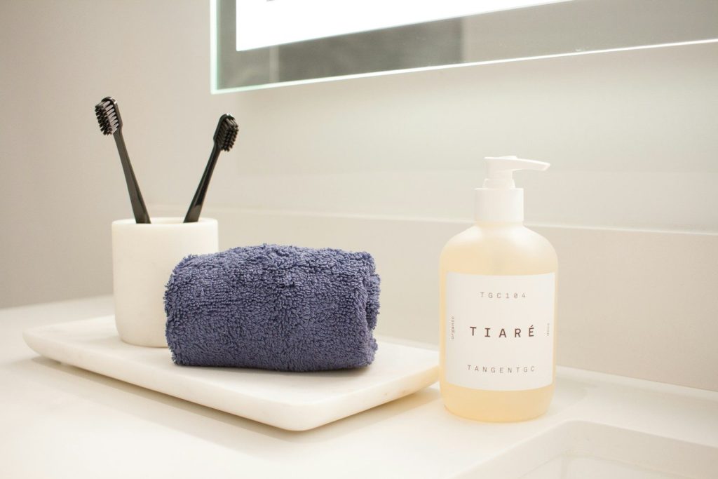 a bathroom counter with a soap, toothbrush, and soap dispenser