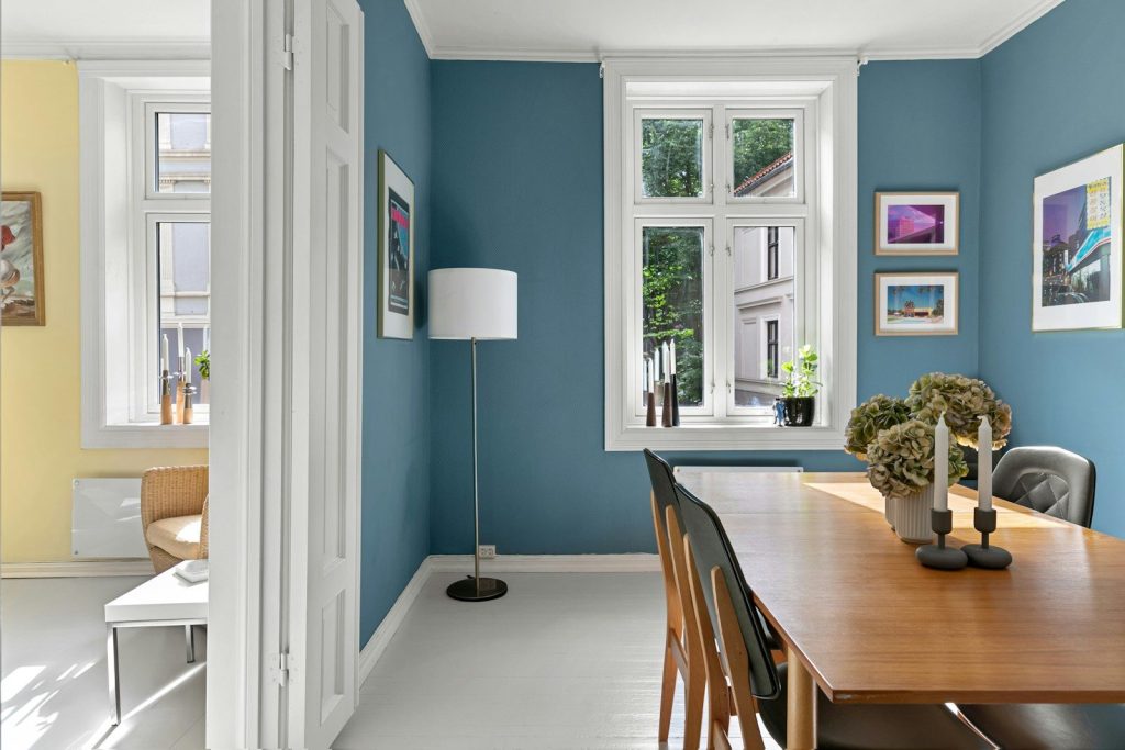 A dining room with blue walls and a wooden table