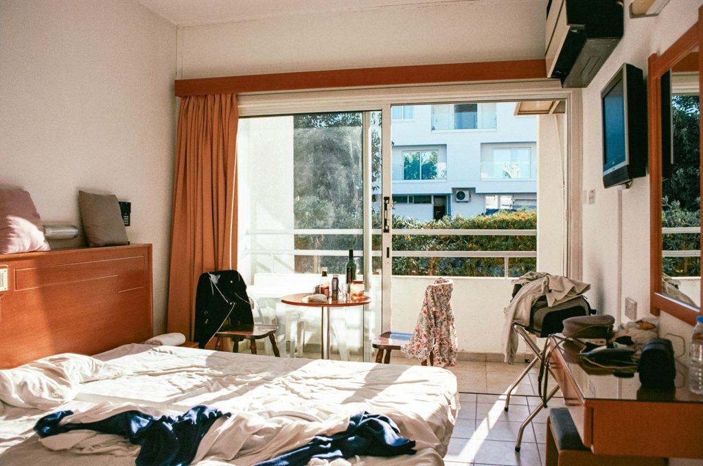 a bed room with a neatly made bed and a large window
