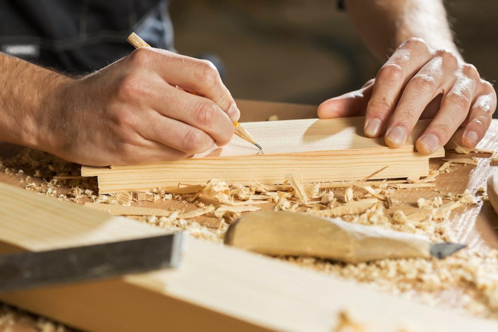 a person cutting a piece of wood
