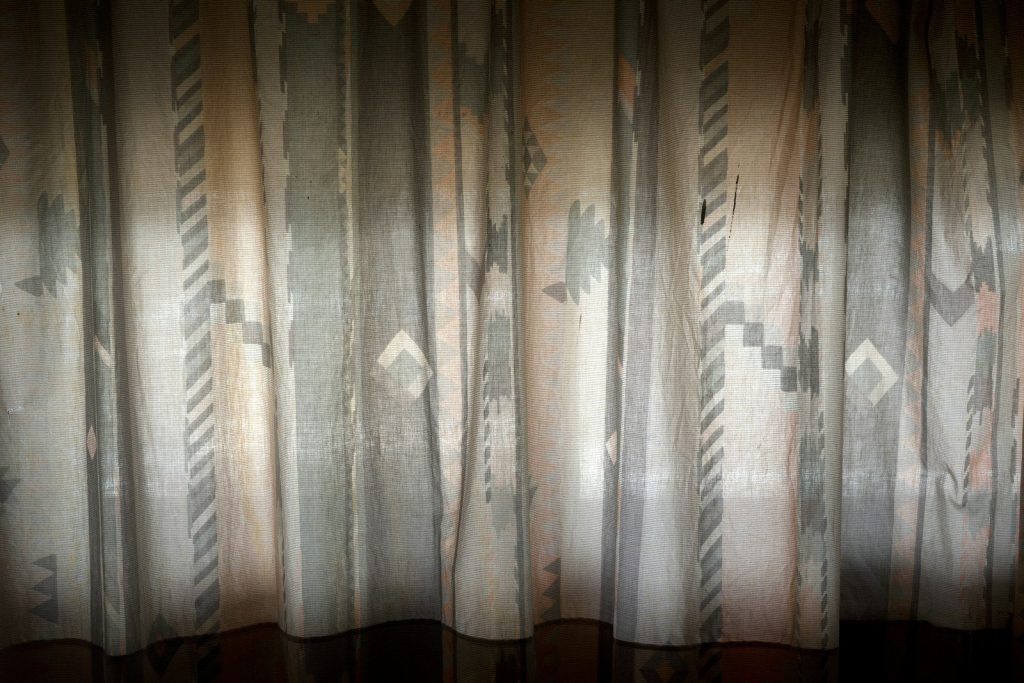 A room with a curtain that has a pattern on it