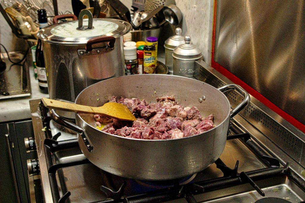 a pot full of meat cooking on a stove