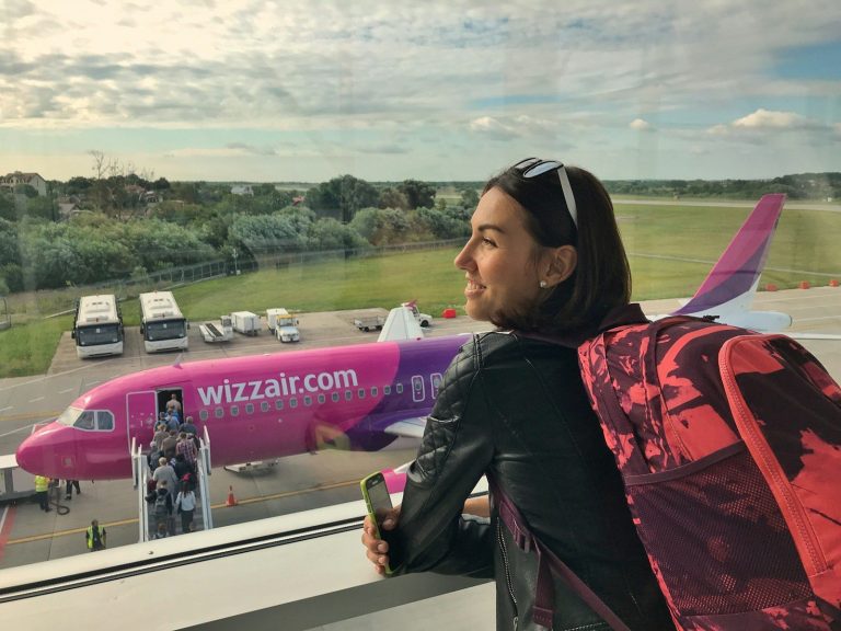 a woman looking out a window at an airplane