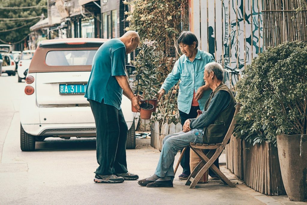 man in blue polo shirt and blue denim jeans standing beside woman in black and white