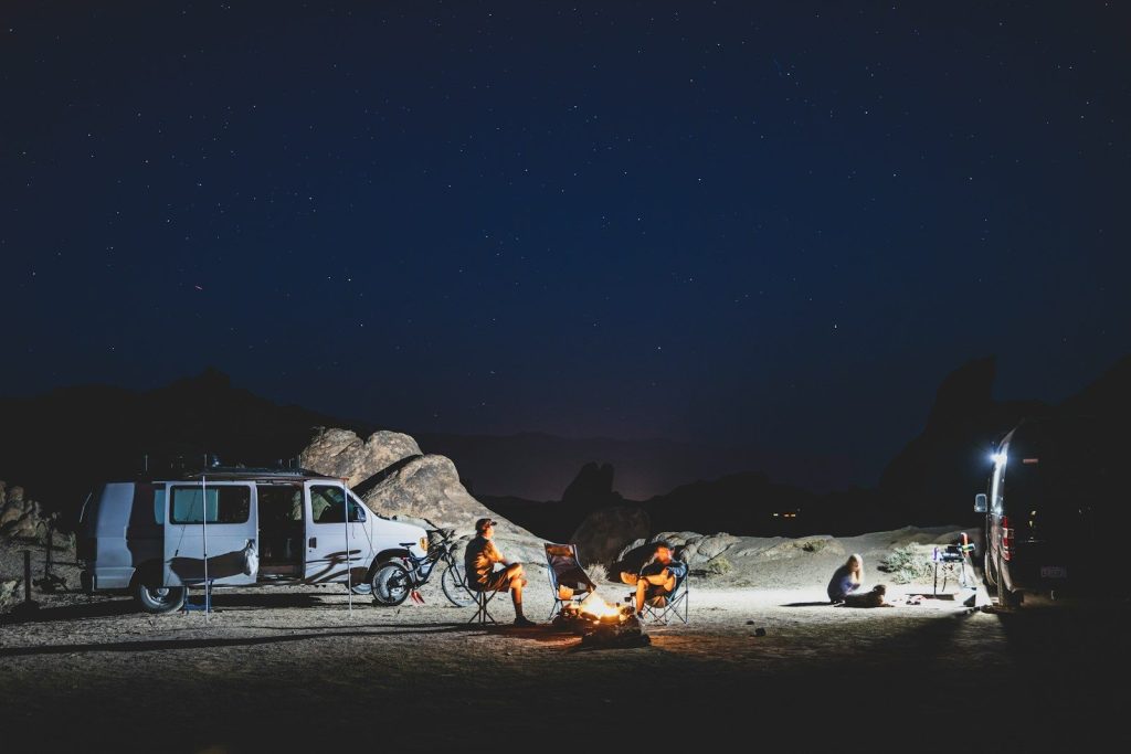 a couple of people sitting around a campfire