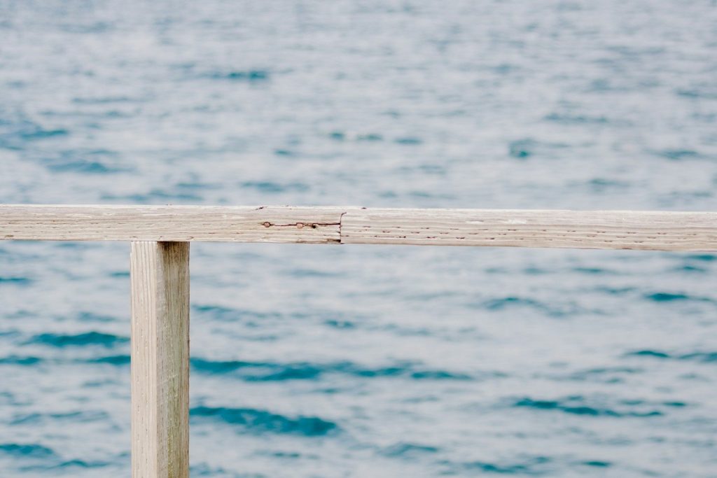 A wooden railing overlooking the ocean.