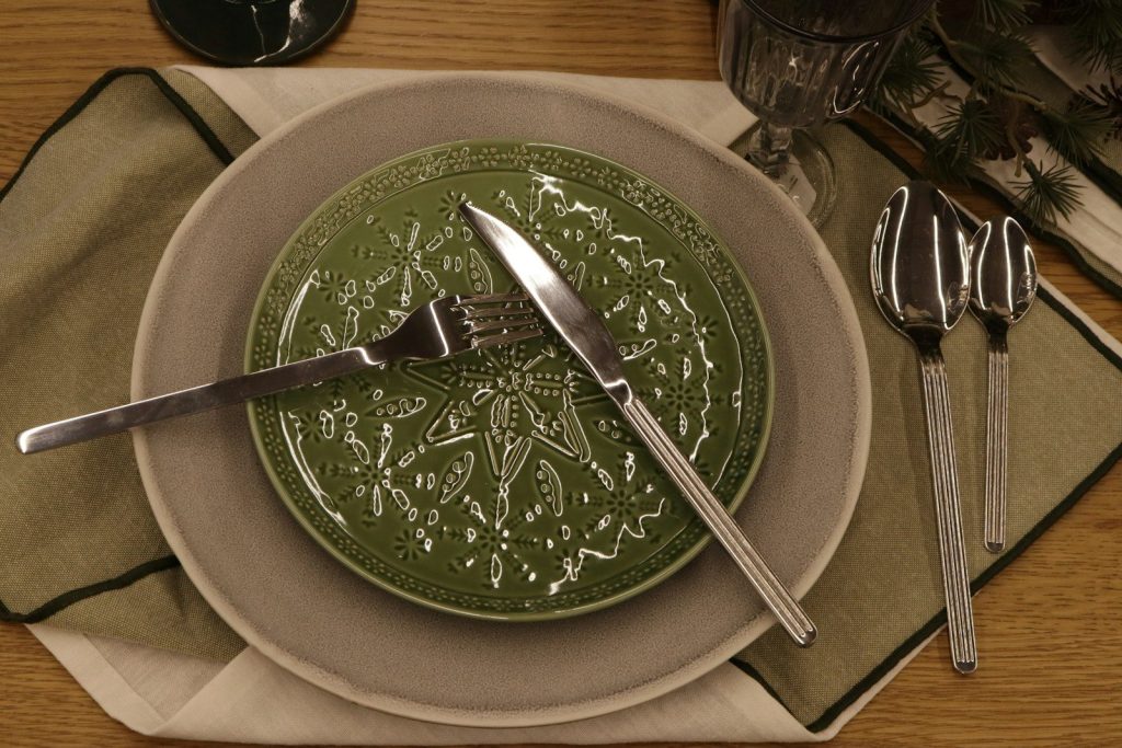 A place setting with a green decorative plate.