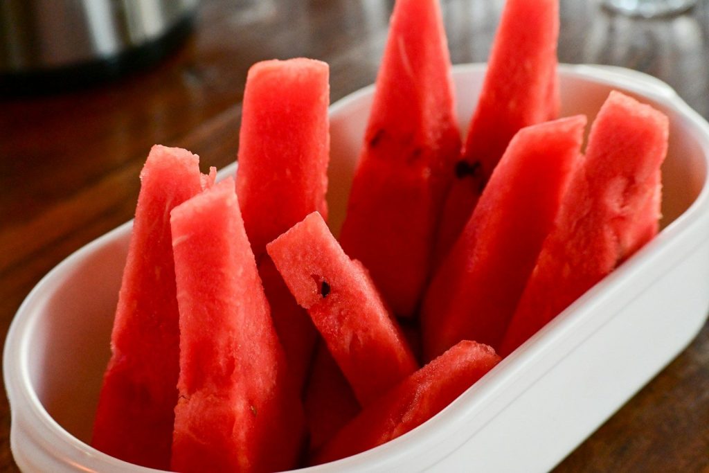 a white bowl filled with slices of watermelon