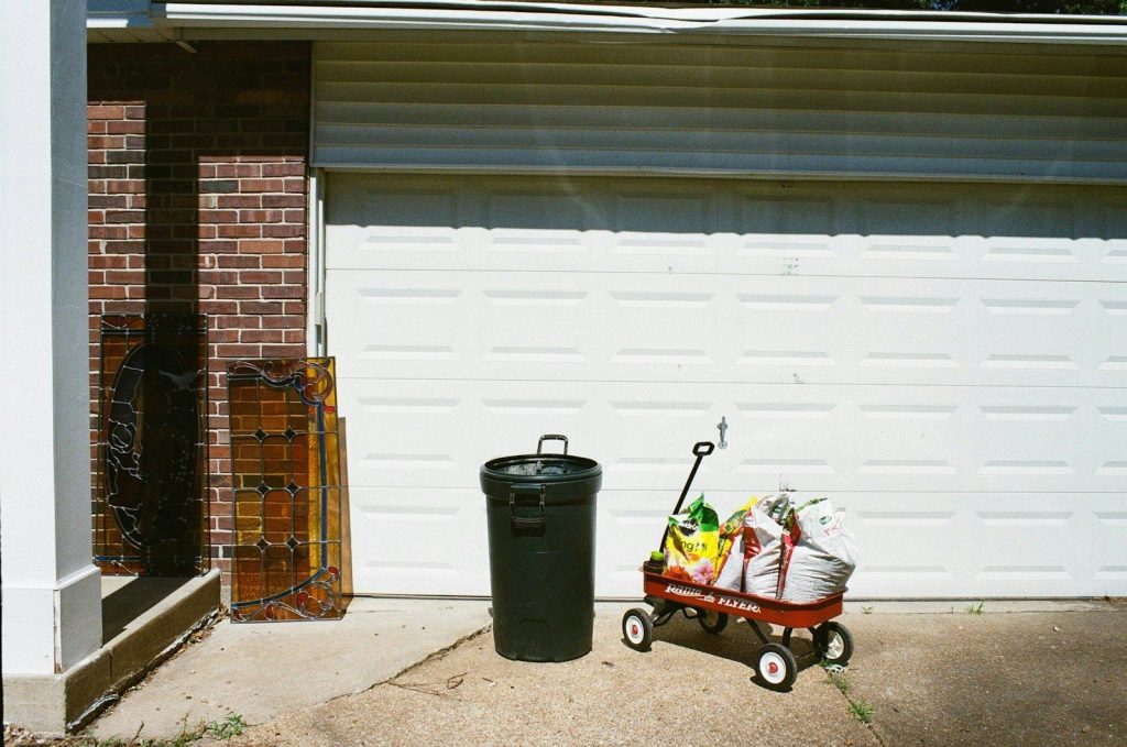 a red wagon filled with bags next to a garage