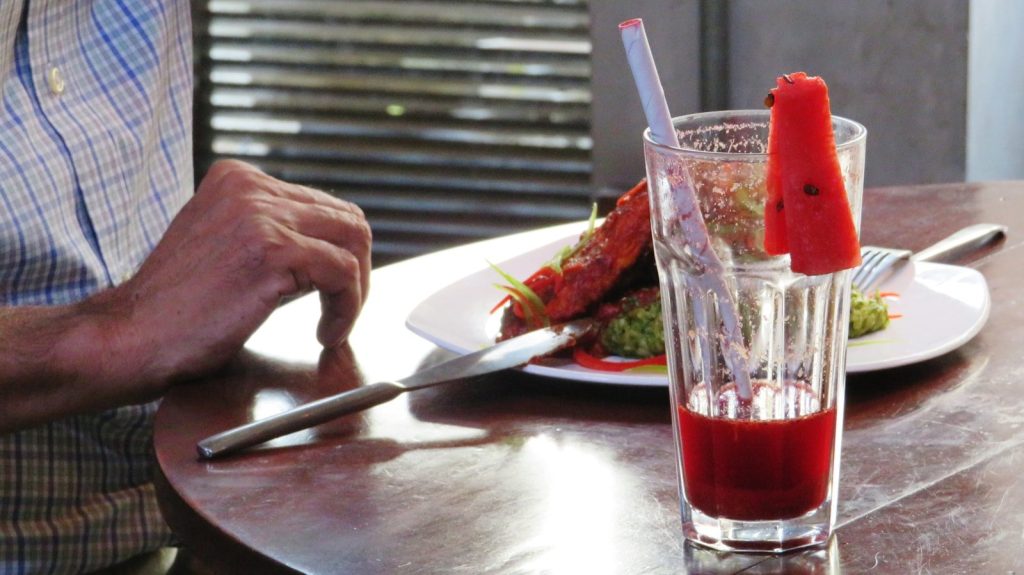 a man sitting at a table with a plate of food