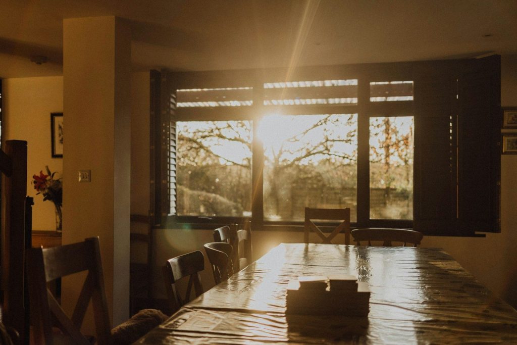 Sunlight streams through a large window onto a dining table.