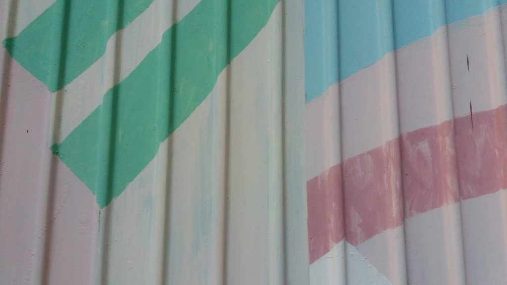 a close up of a metal roof with a green arrow painted on it