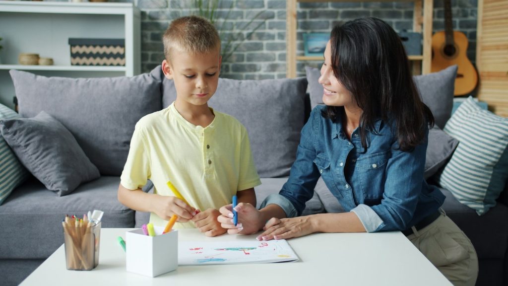 Mother and son drawing together at a table.