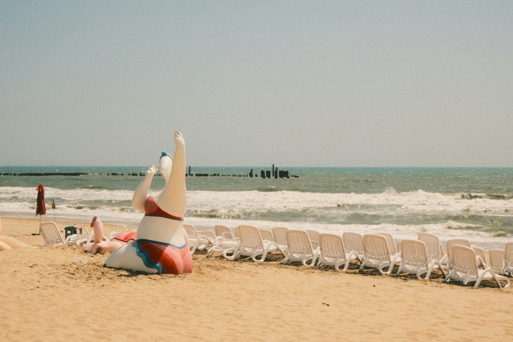 Beach chairs and inflatable swan by the ocean